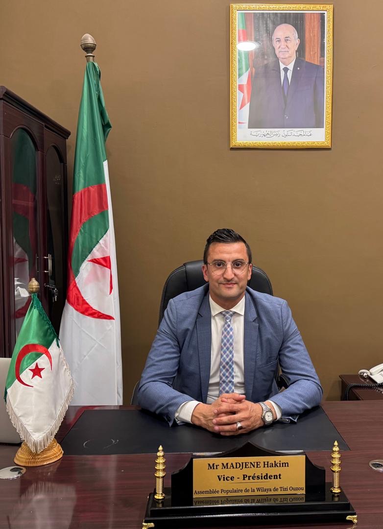 Hakim Madjene au bureau du Vice-Président de l'APW de Tizi-Ouzou, devant le drapeau algérien et le portrait du Président Tebboune